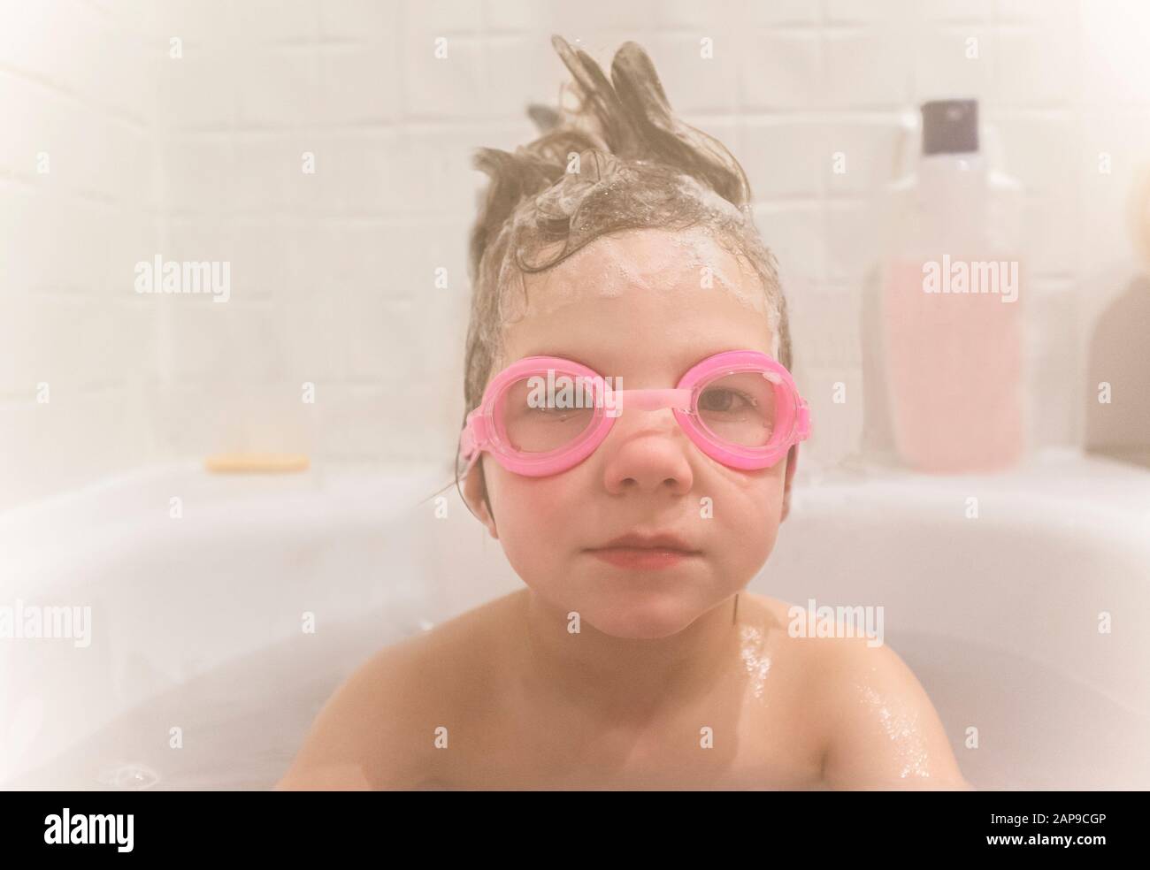 4 years boy wearing goggles at bathtub. Visible steam all arround Stock Photo