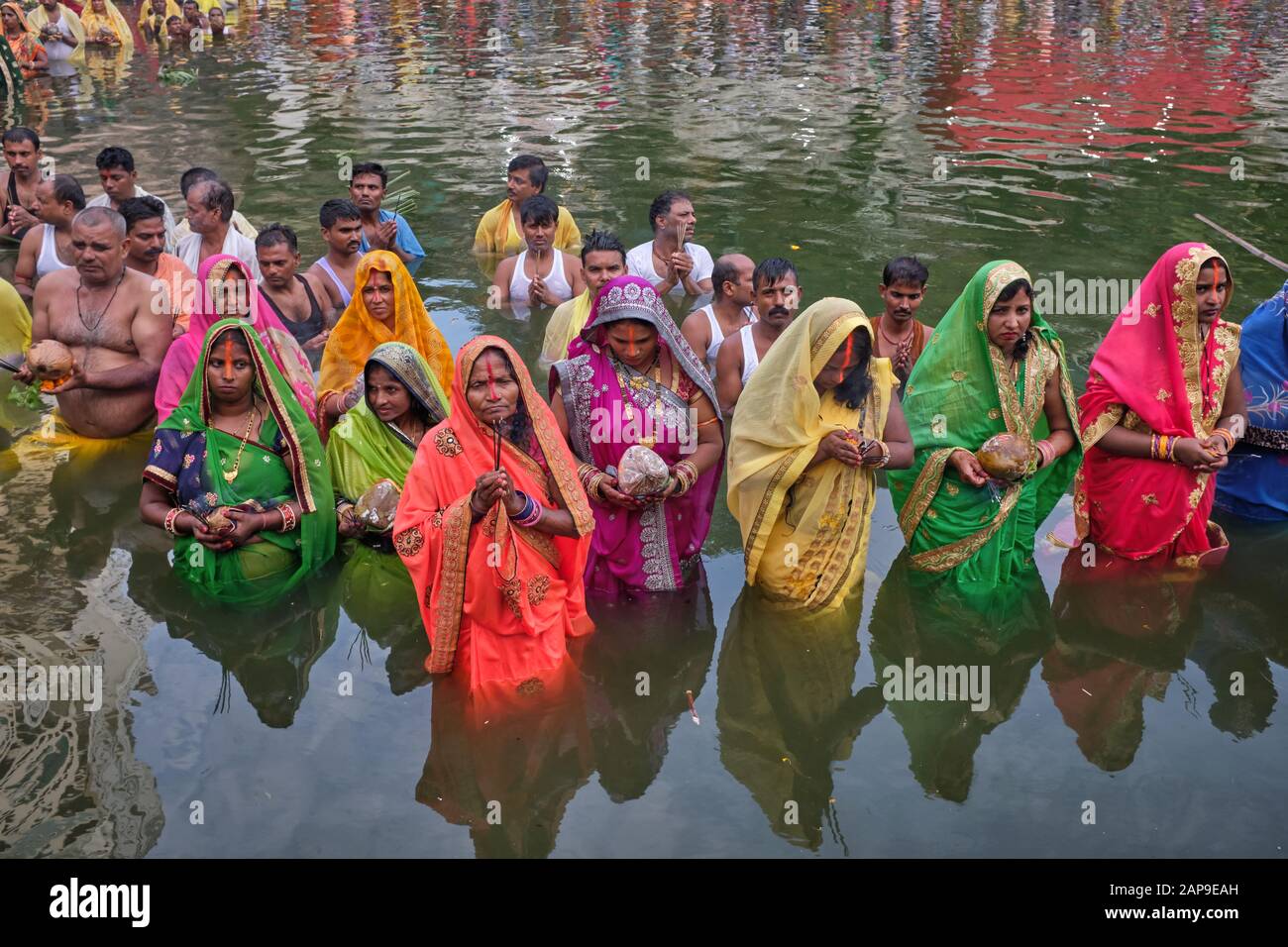 For Hindu festival Chhath Puja, worshippers, most of Bihari background,  are standing in Banganga Tank, Mumbai, India, praying towards the setting sun Stock Photo