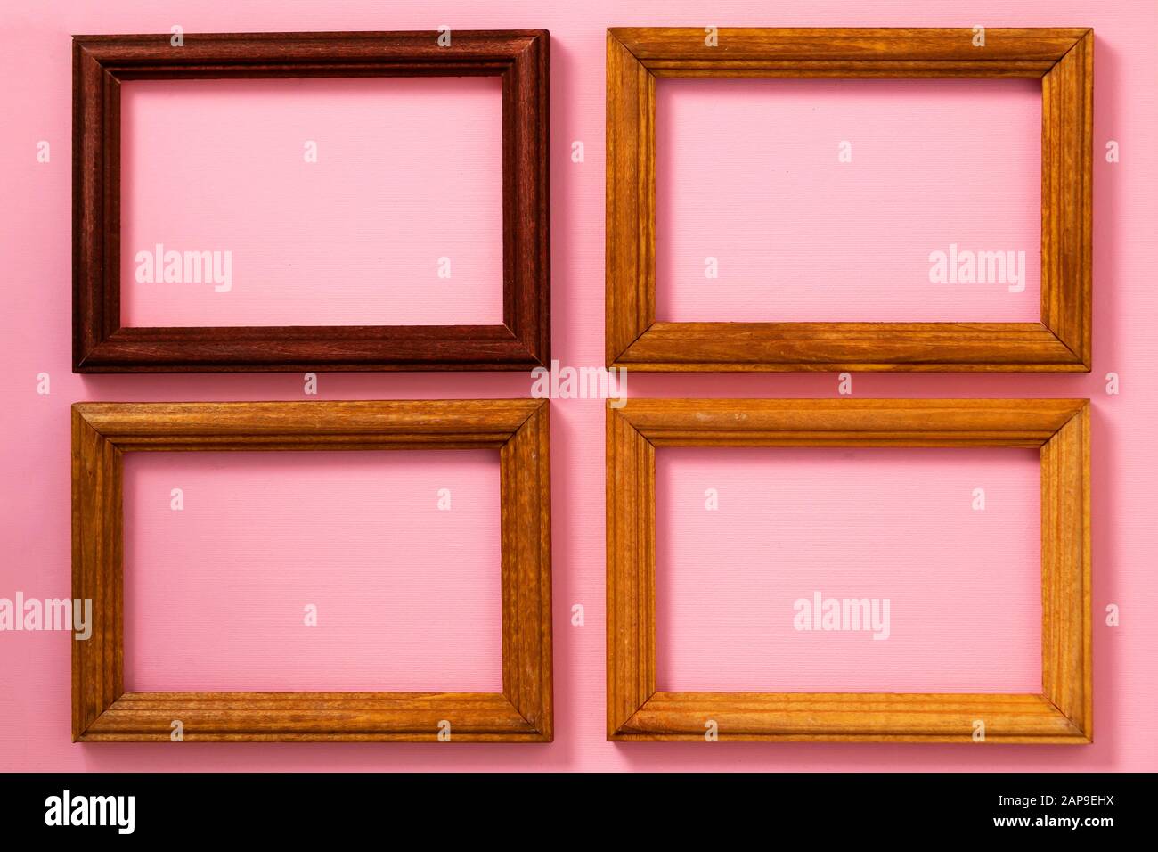 Four wooden picture frames with empty space on the paper the pink background, top view Stock Photo