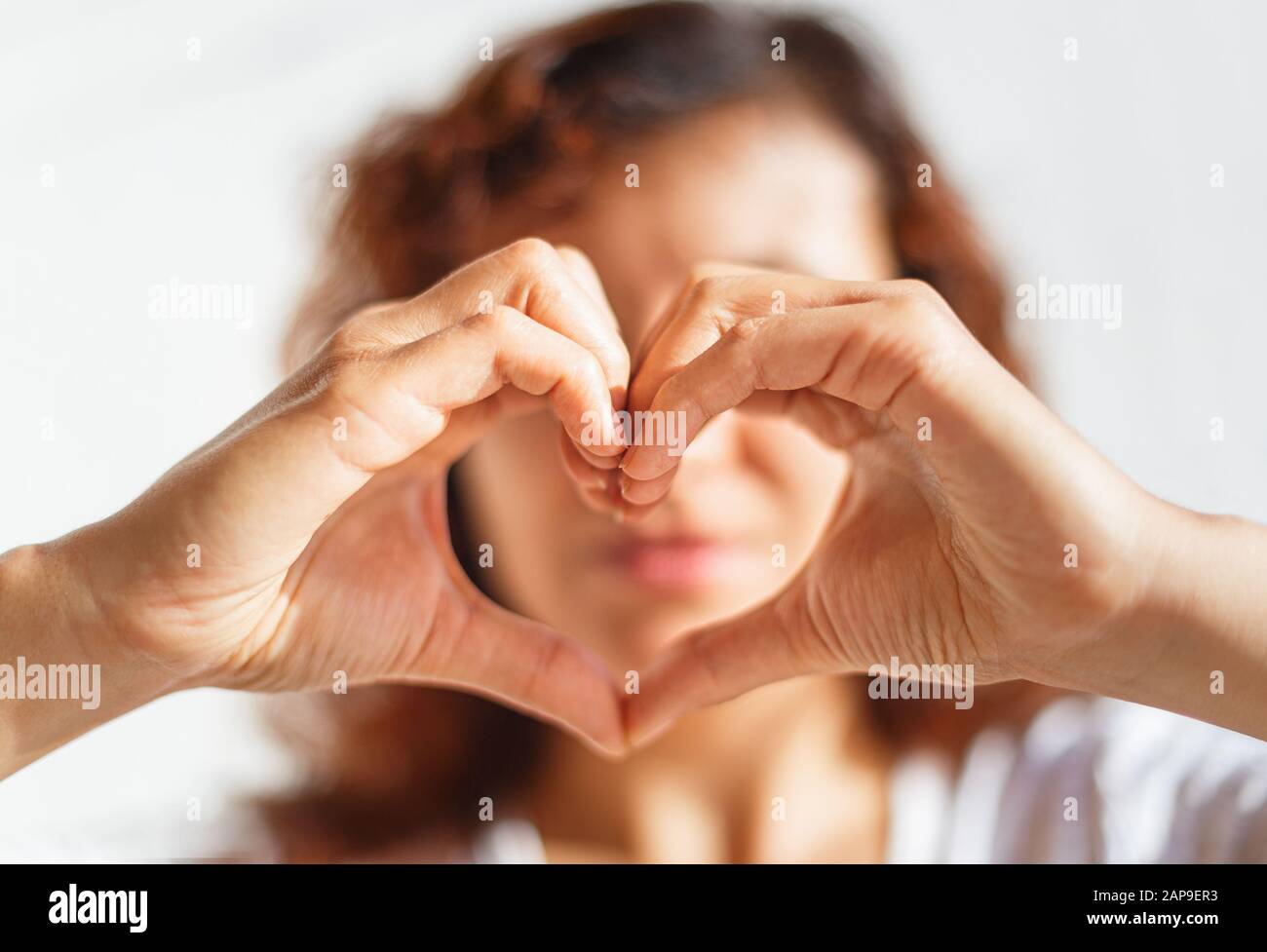 Woman and white heart in your hand. Stock Photo
