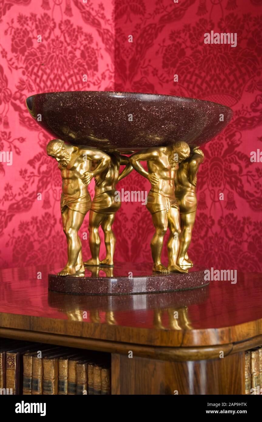 Ormolu and porphyry ornament in the Sitting Room at Hinton Ampner, Hampshire, against the red damask which was hung in 1960 following the fire. Stock Photo