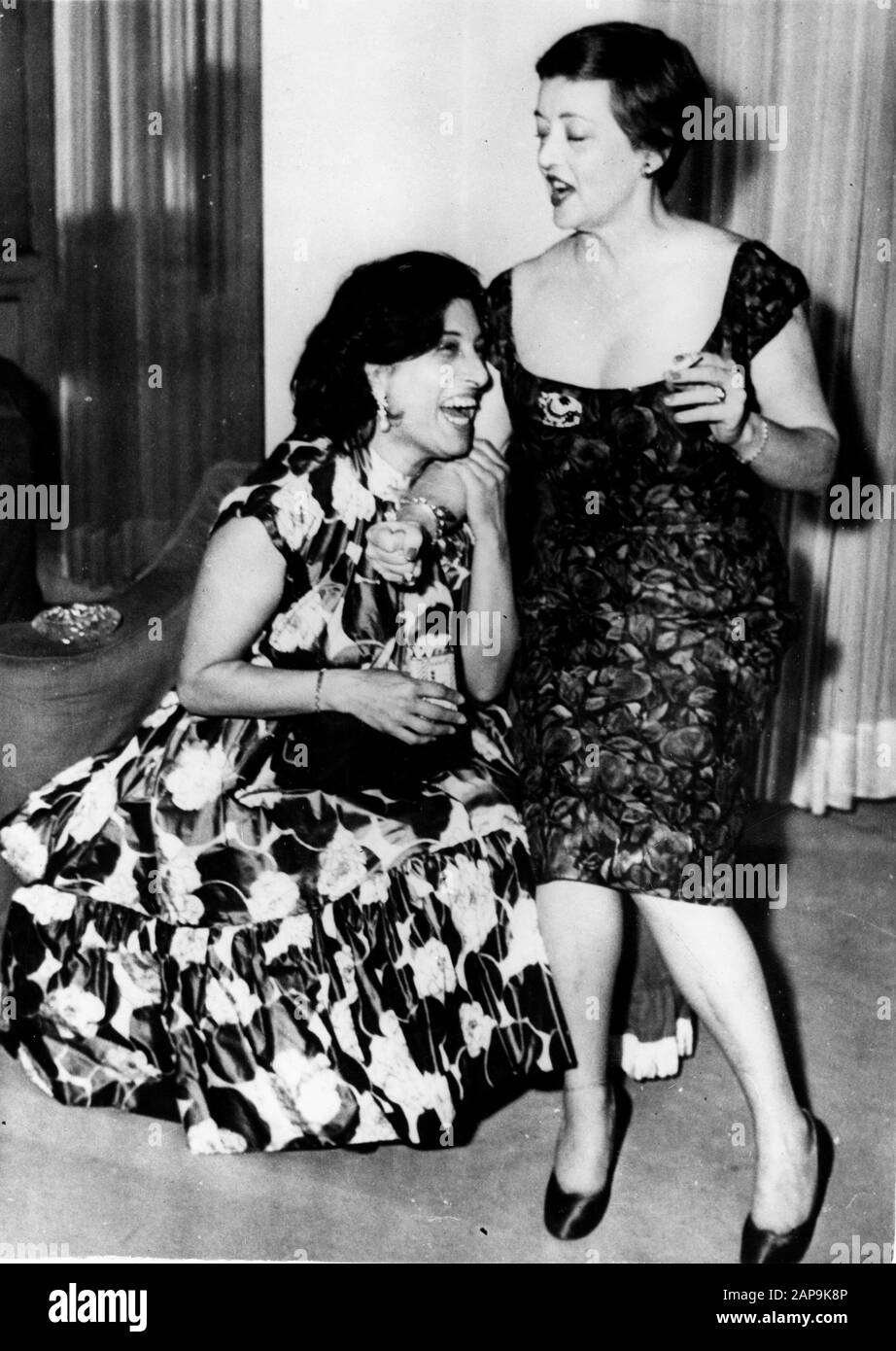 June 4, 1958, Rome, Italy: Movie super star actresses ANNA MAGNANI, 50 and BETTE DAVIS, both 50 years old and at top of their game. Anna Maria Magnani the Italian stage and film actress. Widely regarded as one of the greatest actresses of Italian and World cinema, Known for her explosive acting and earthy, real life portrayals of characters. shares a laugh, while attending a party held by Italian dress designer Schubert. Two of the world's most famous screen actors having a great time, talking over their film parts. Bette is in Rome for filming of ''John Paul Jones'', in which she plays the pa Stock Photo