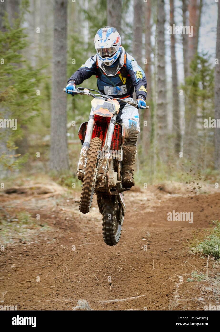Motocross driver jumping with the bike at high speed on the race track. Stock Photo