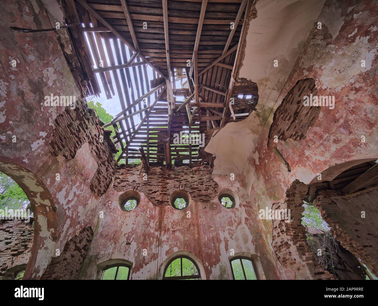 Interior view of the old abandoned St. Nicholas Church ruins in Estonia. Green forest covering the beauty of this ancient ruined building. Stock Photo