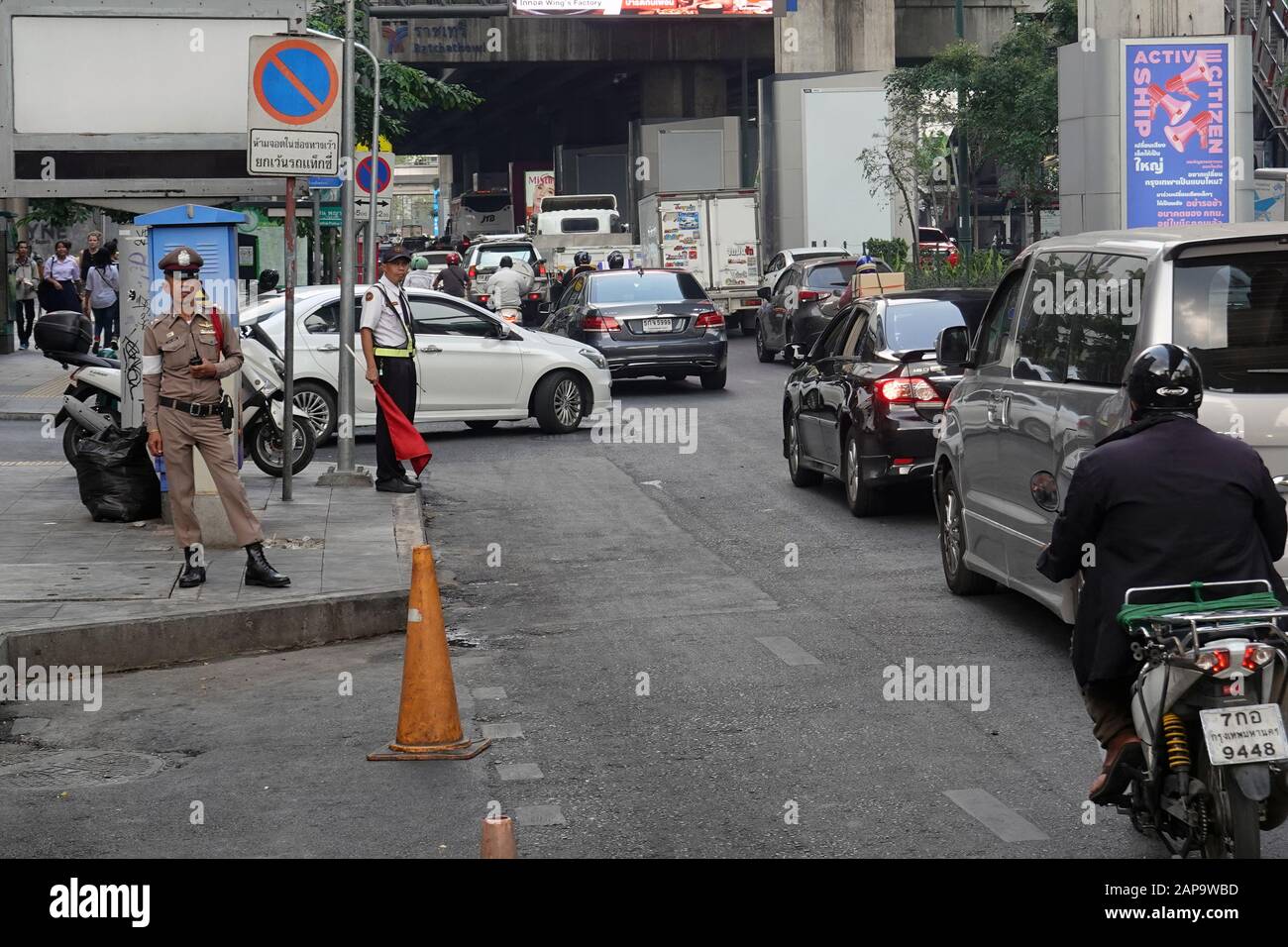 Bangkok, Thailand - December 25, 2019: Traffic on Phaya Thai Road, near Ratchathewi BTS skytrain station. Police officers on roadside. Stock Photo