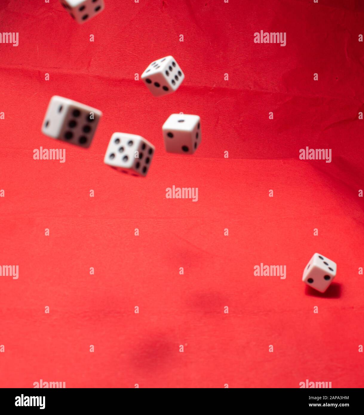 Hand throwing dice, hoping for the best odds. Six dice on red