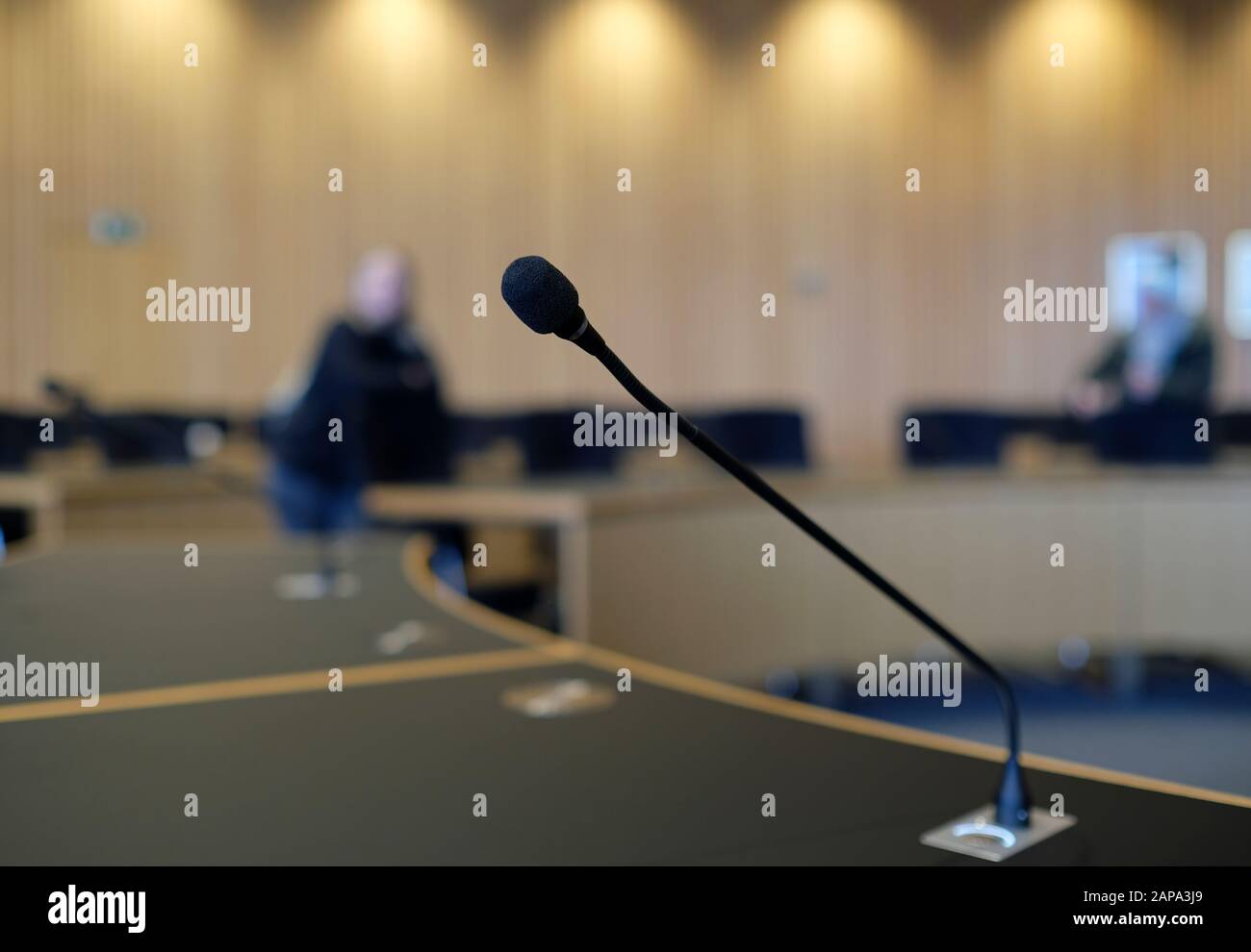 Conference room with wooden walls and microphones at each seat Stock Photo