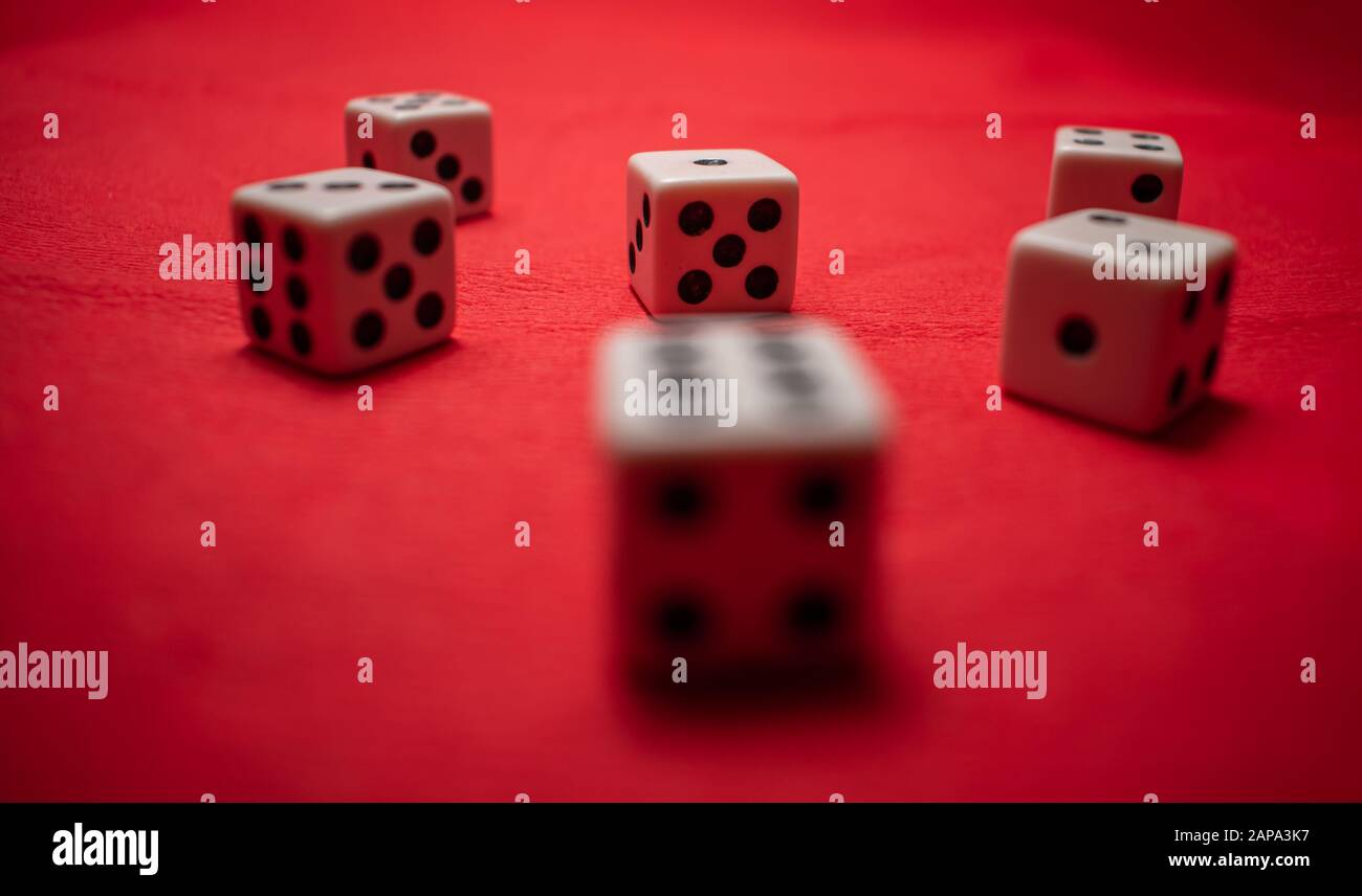 Hand throwing dice, hoping for the best odds. Six dice on red