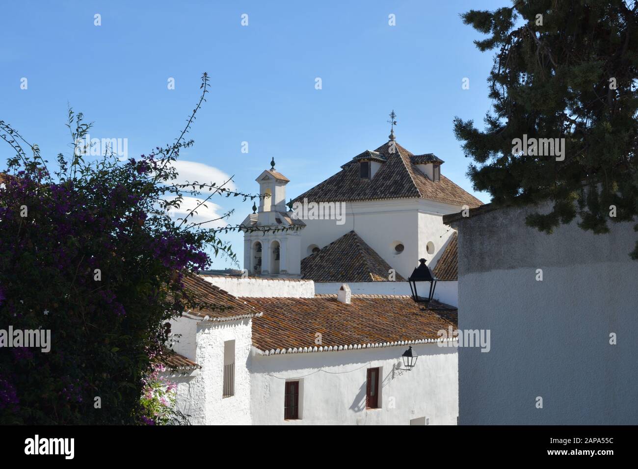 View of Macharaviaya church from a typical andalusian whitewashed street Stock Photo