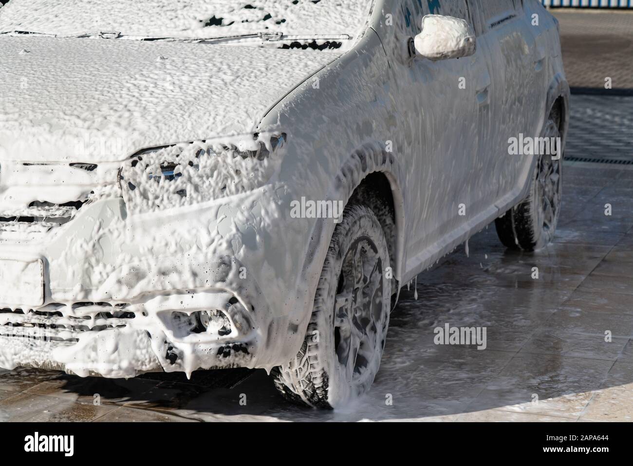 Self service high pressure car wash. Vehicle covered with foam Stock Photo