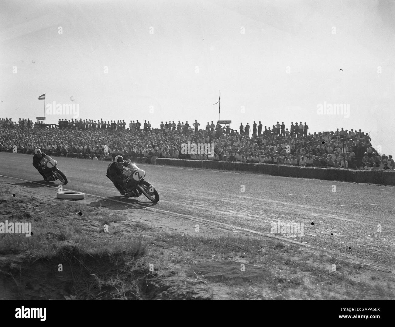 TT Assen 1955 Description: Drivers in the turn Annotation: 500cc Reg Armstrong (2), Geoff Duke (1) Date: 16 July 1955 Location: Axis Keywords: Motorsport Institution name: TT Stock Photo