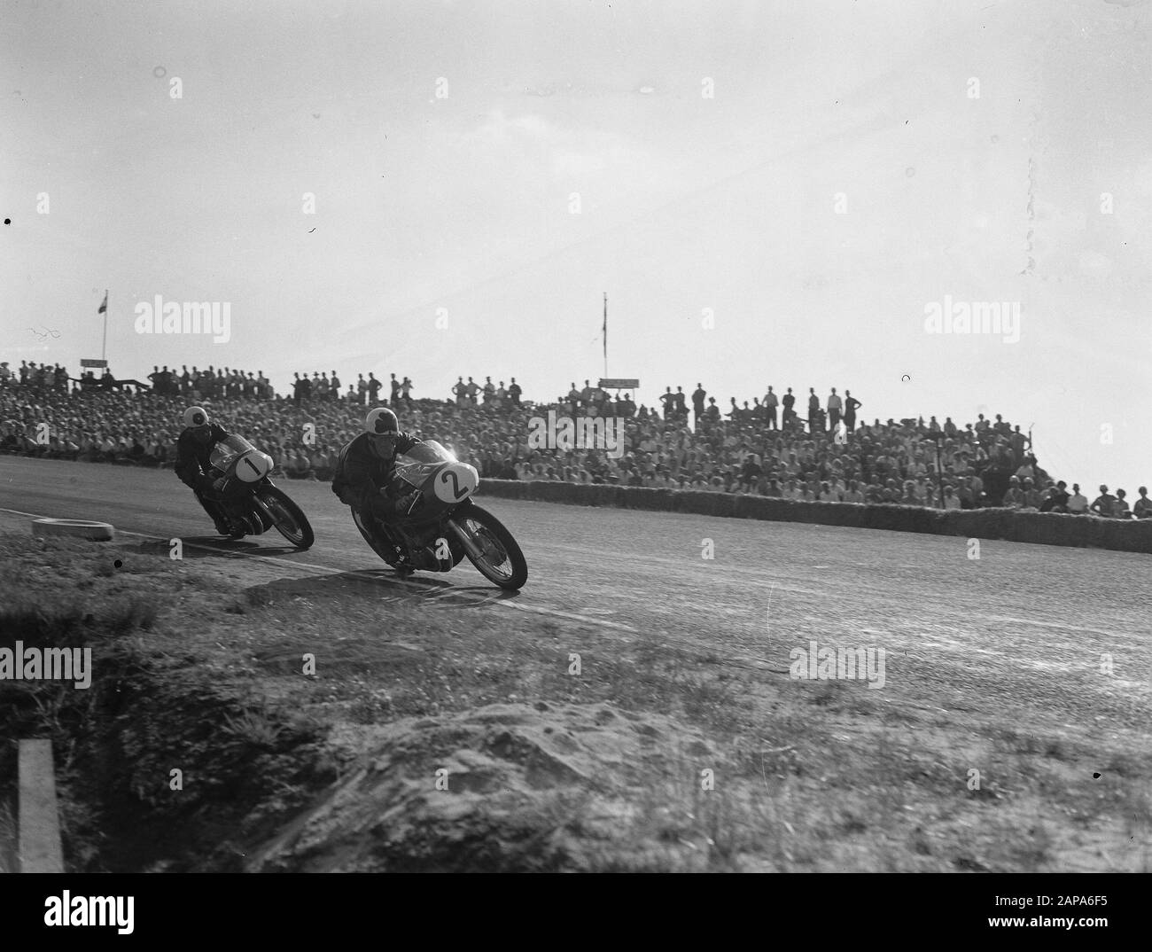 TT Assen 1955 Description: Drivers in the turn Annotation: 500cc Reg Armstrong (2), Geoff Duke (1) Date: 16 July 1955 Location: Axis Keywords: Motorsport Institution name: TT Stock Photo