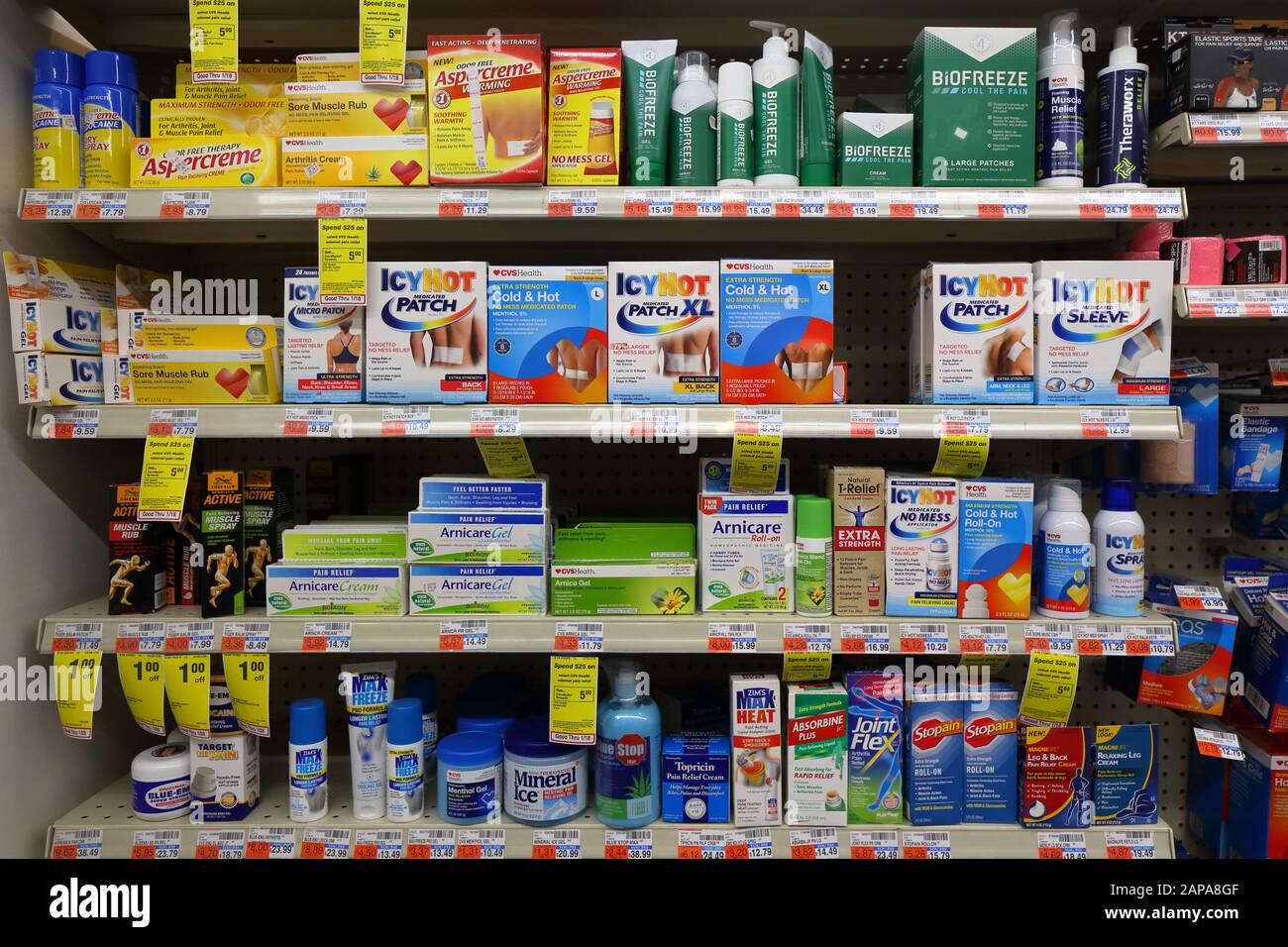 Many different brands of pain relief gels and creams on a shelf at a drug store pharmacy Stock Photo