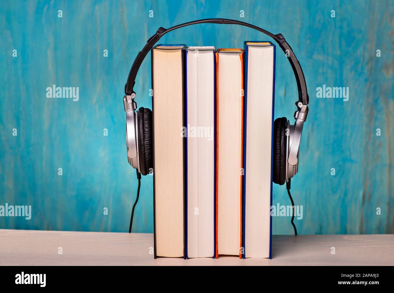 Headphones with four books as symbol for audio books Stock Photo