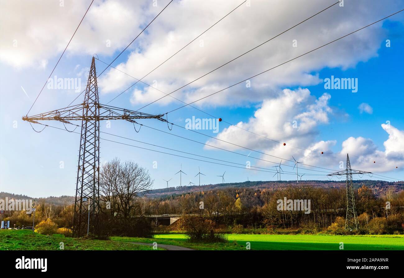 Power pylons and windmills in Spessart Stock Photo