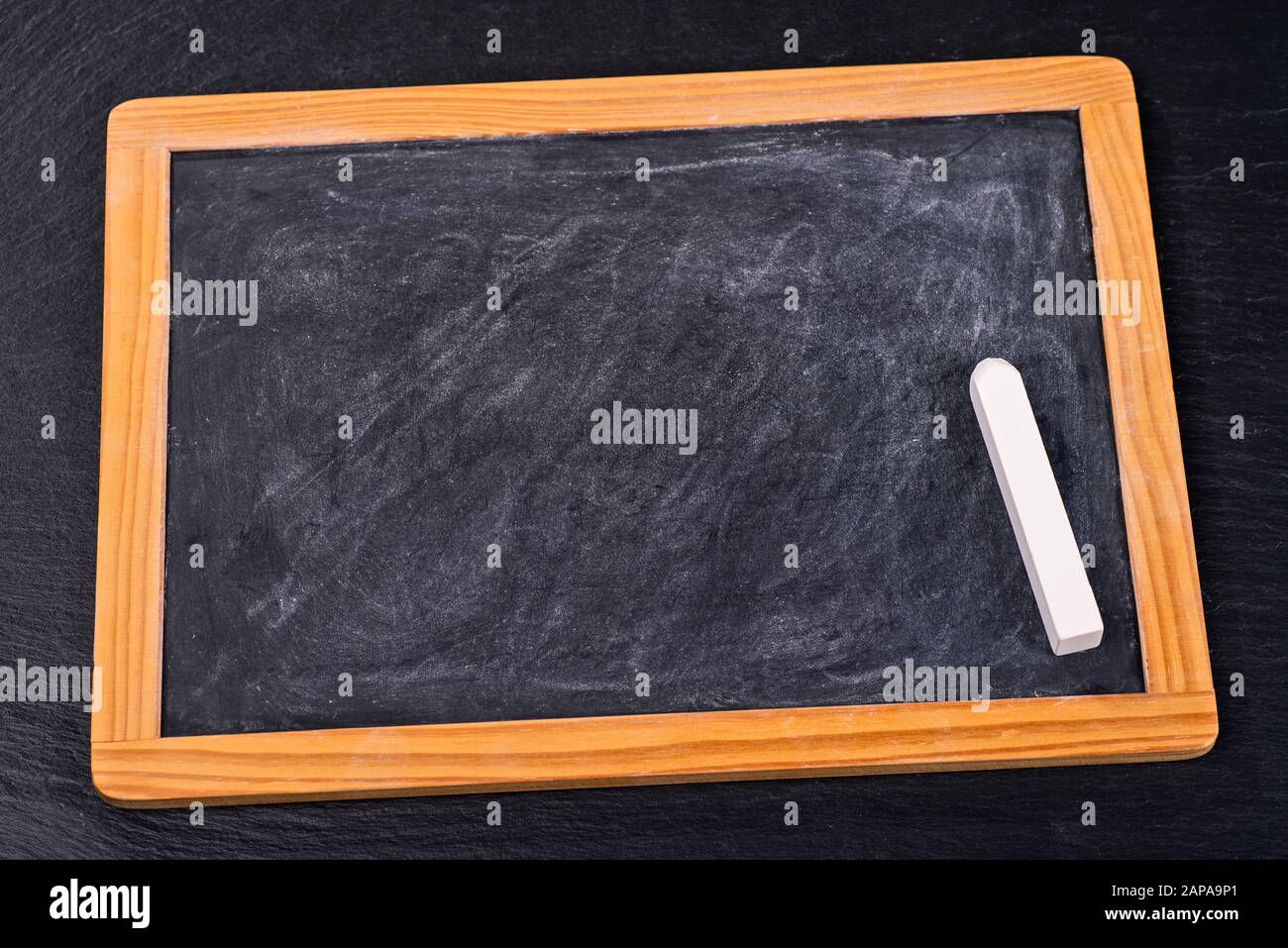 A piece of chalk lies on a small board Stock Photo