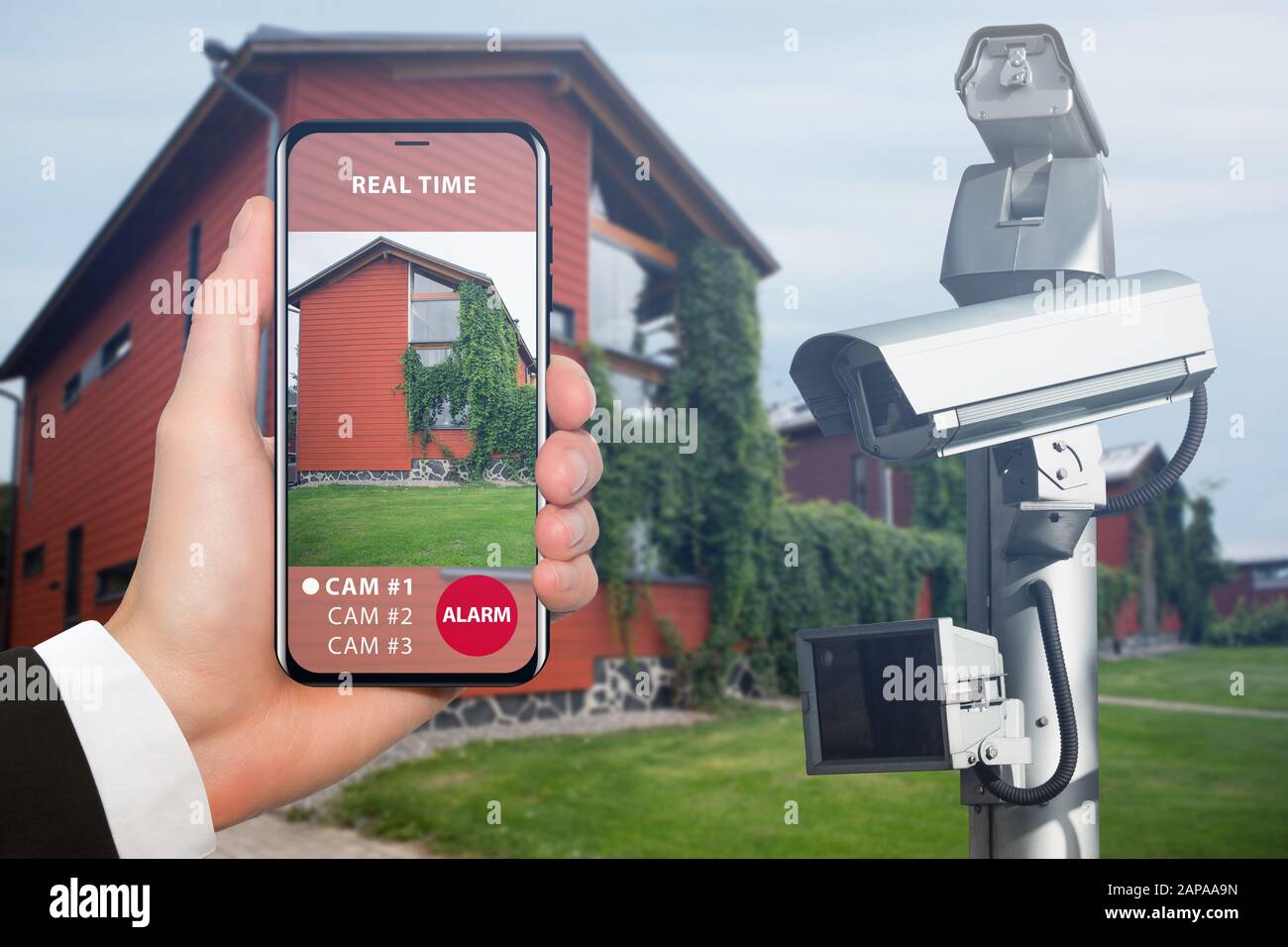 Hand with phone. On the screen interface of remote control surveillance camera Stock Photo