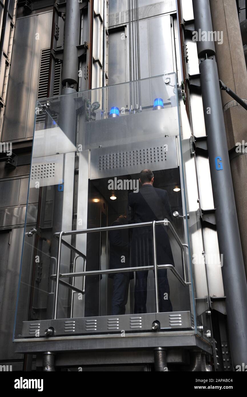 People ride in the lifts at The Lloyd's of London building in Lime Street, London, England Stock Photo