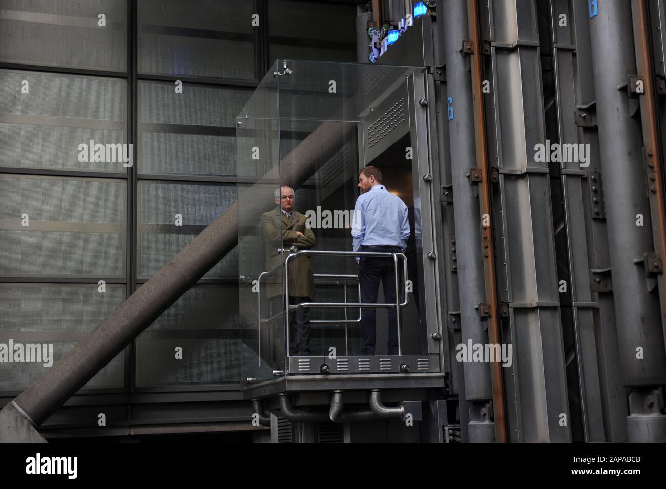 People ride in the lifts at The Lloyd's of London building in Lime Street, London, England Stock Photo