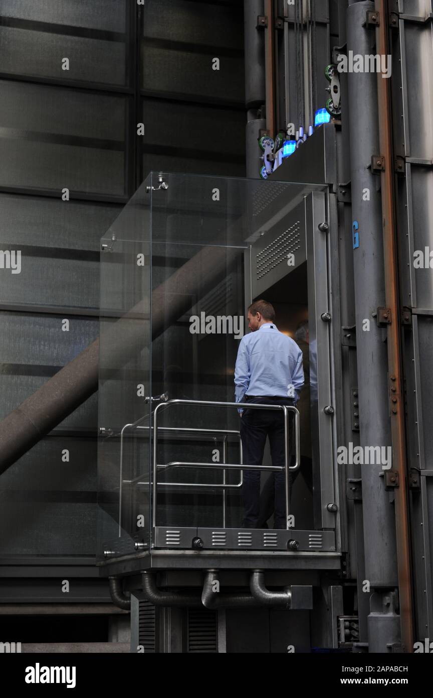 People ride in the lifts at The Lloyd's of London building in Lime Street, London, England Stock Photo