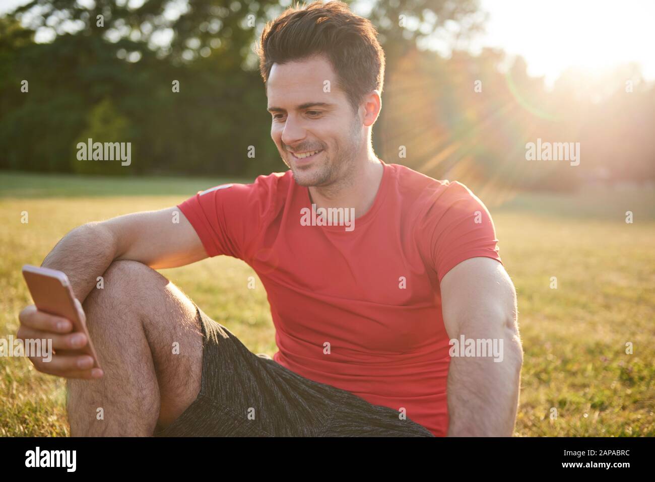 Smiling man using mobile phone after workout Stock Photo