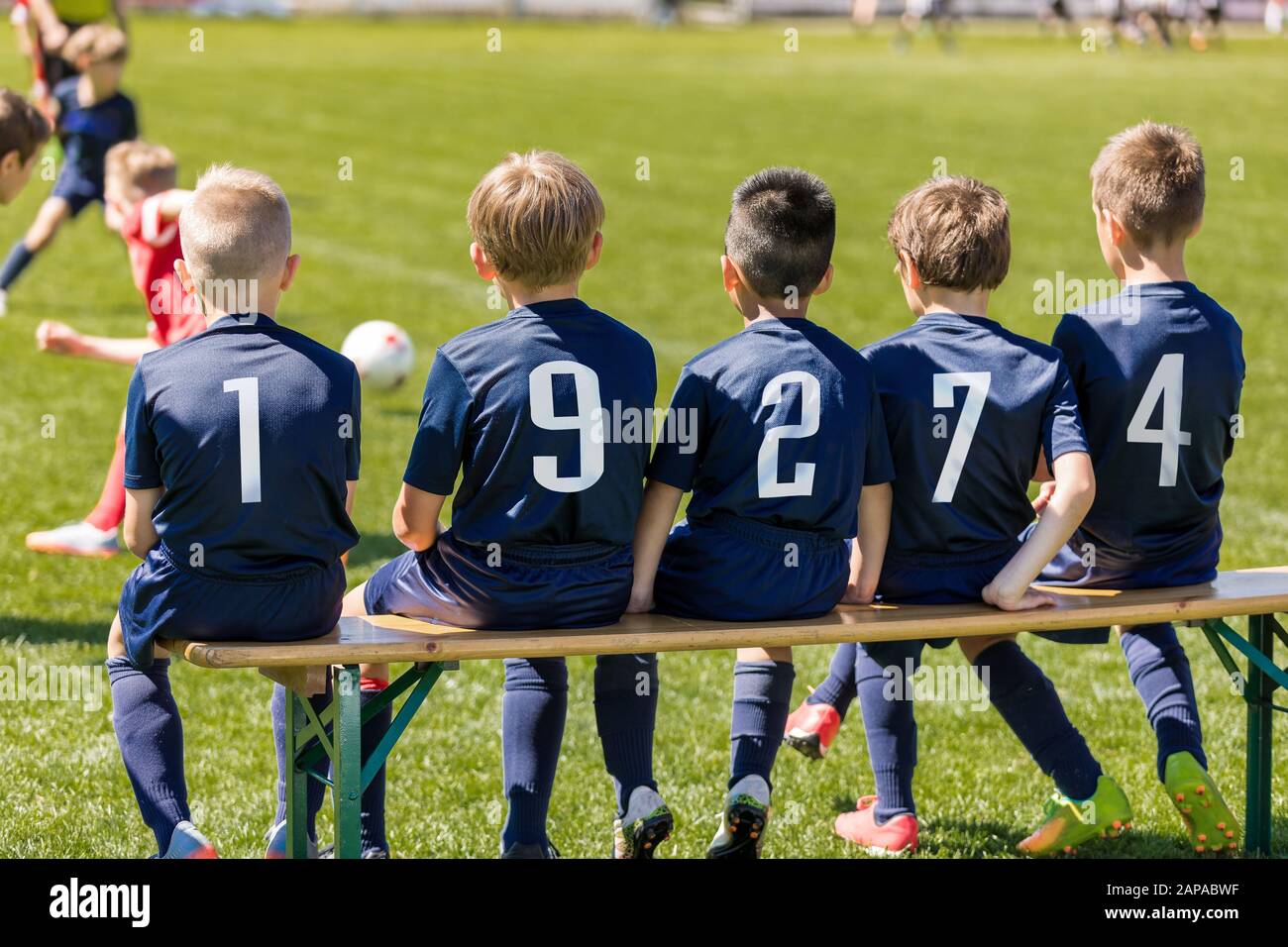 Friends on a Soccer Team Sitting on a Wooden Bench. Group of Interracial  Kids in a School Sports Team Stock Photo