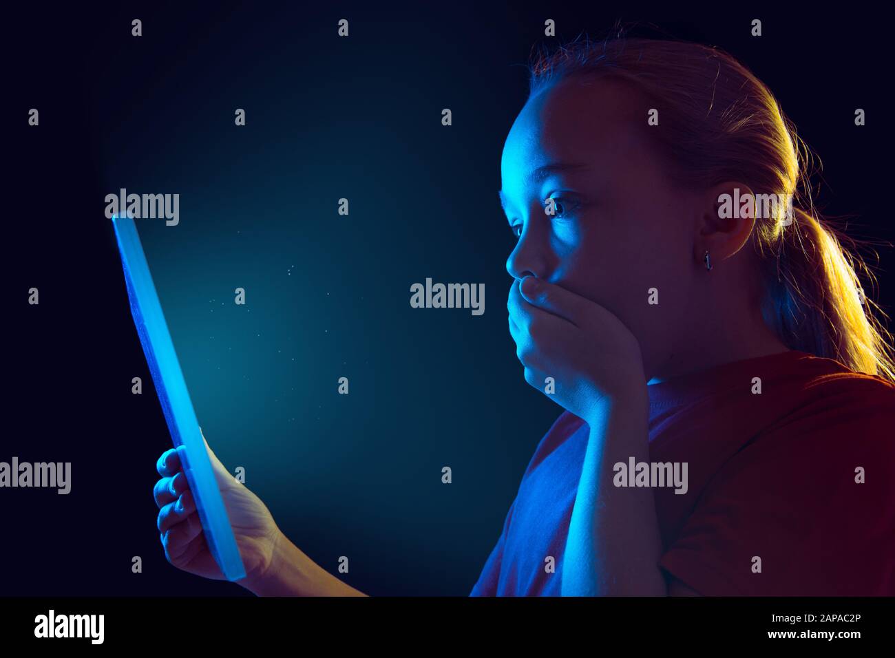 Shocked, scared. Caucasian girl's portrait on dark studio background in