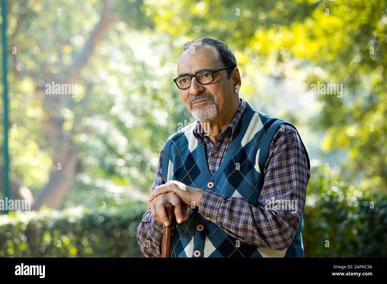 Thoughtful old man sitting on park alone Stock Photo