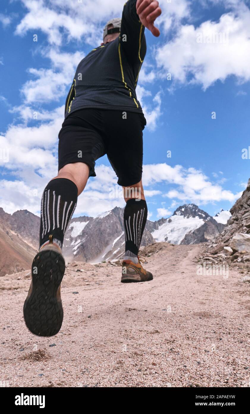 Closeup of feet with running shoes of a trailrunner man running in the