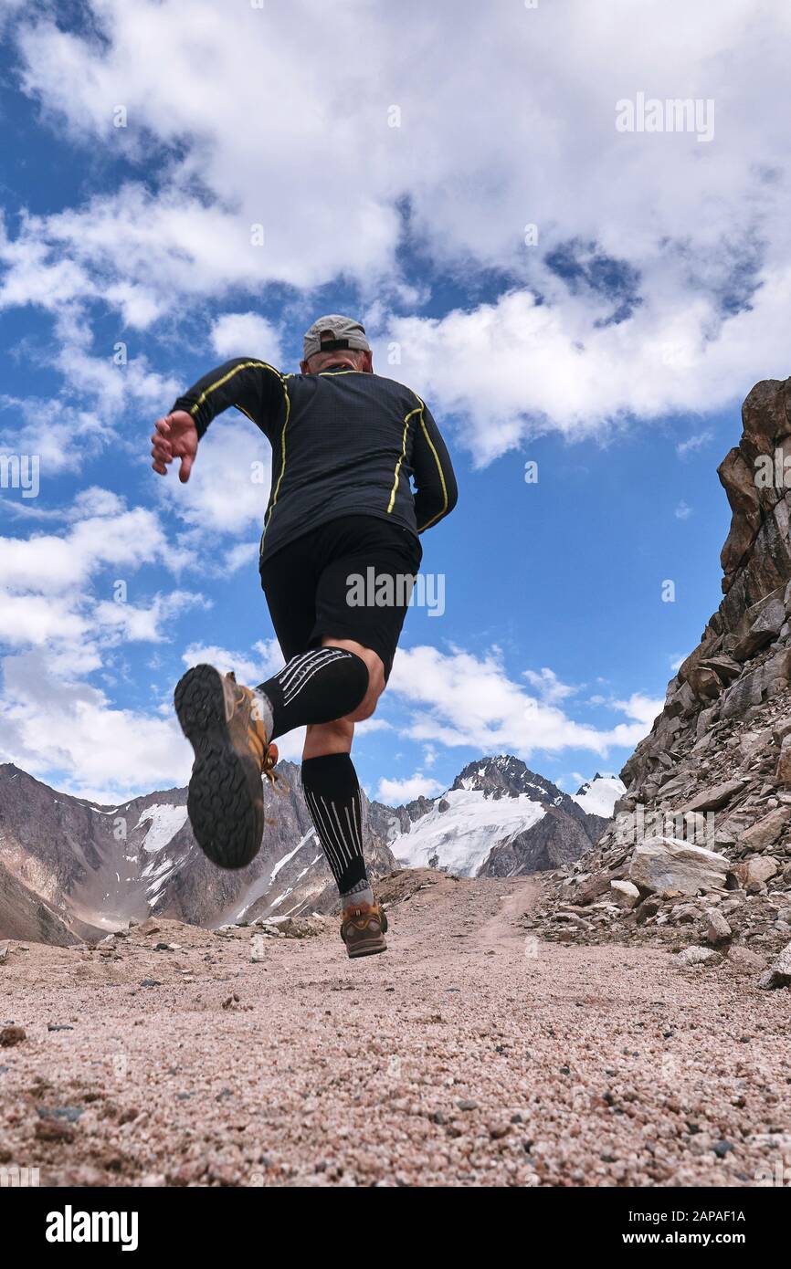 Closeup of feet with running shoes of a trailrunner man running in the