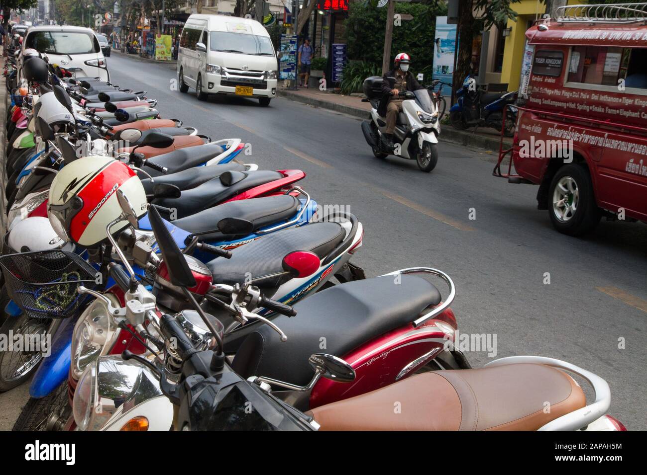 motor bikes parked i row line Chiang Mai street Thailand Stock Photo