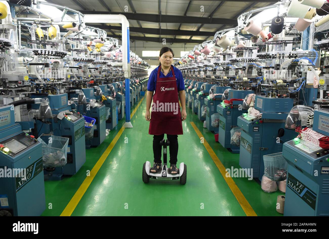 (200122) -- HANGZHOU, Jan. 22, 2020 (Xinhua) -- A worker inspects machines at a smart workshop of a hosiery company in Zhuji, east China's Zhejiang Province, Oct. 23, 2019. TO GO WITH 'Xinhua Headlines: Economic powerhouse leads legislation in beefing up private sector' (Xinhua/Han Chuanhao) Stock Photo