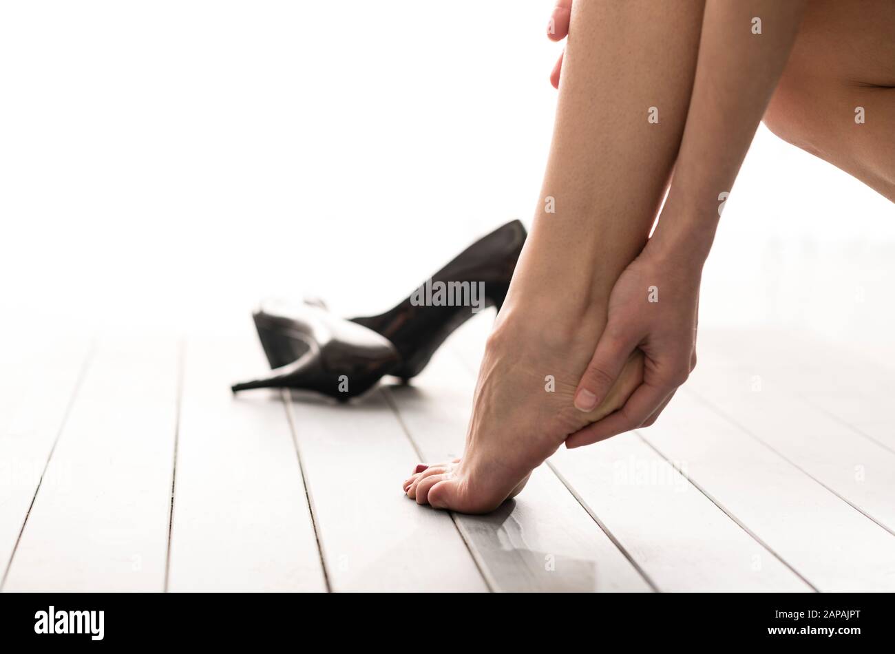 Barefoot Woman with High Heels on Floor Stock Photo
