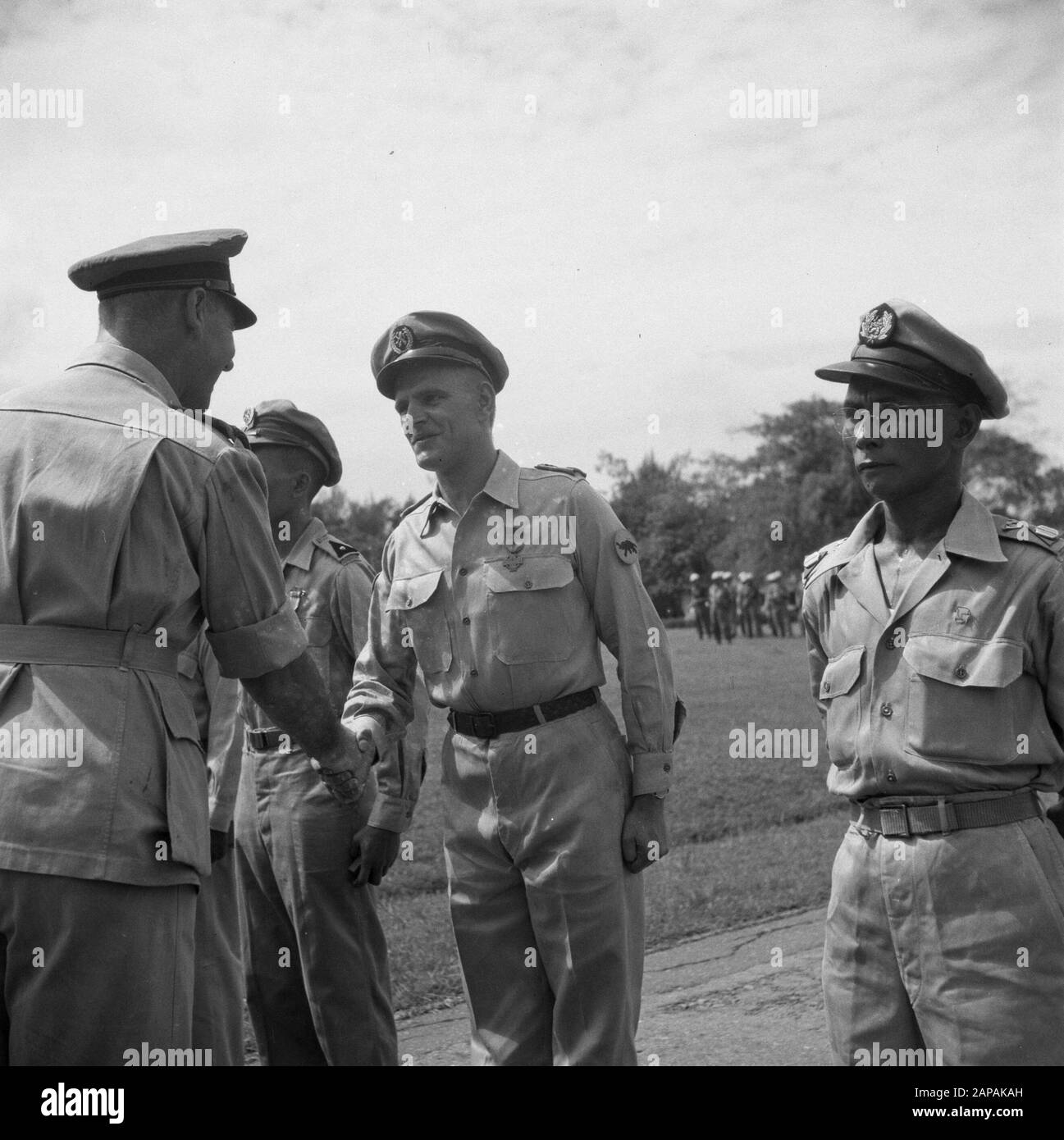 [Ceremony granting awards. A decorated shakes the hand of the issuing officer] Annotation: The man wears the sleeve emblem of the KNIL Infantry X Gadjah Merah Date: 1947 Location: Indonesia, Dutch East Indies, Sumatra Stock Photo
