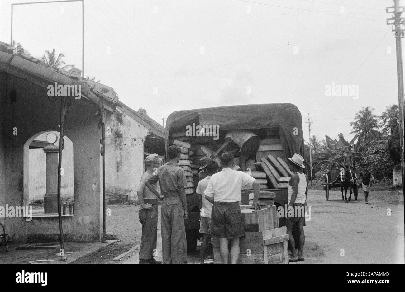 Loaves are unloaded from a truck. Right a dokar Date: 1947/01/01 Location: Indonesia, Dutch East Indies Stock Photo