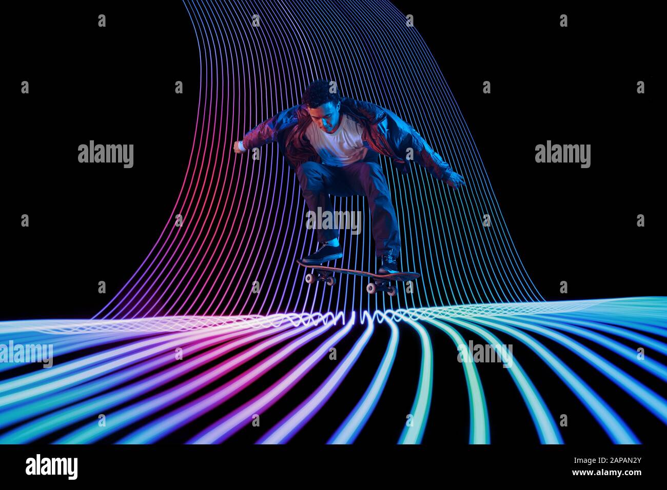 Neon Wave Riding Caucasian young skateboarder riding on dark neon lighted line ...
