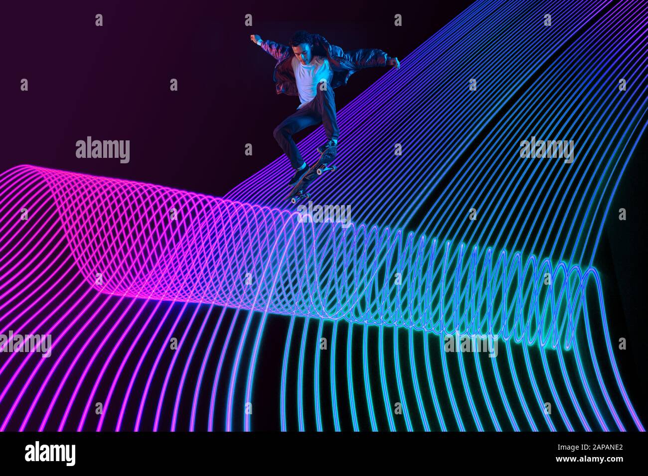 Neon Wave Riding Caucasian young skateboarder riding on dark neon lighted line ...