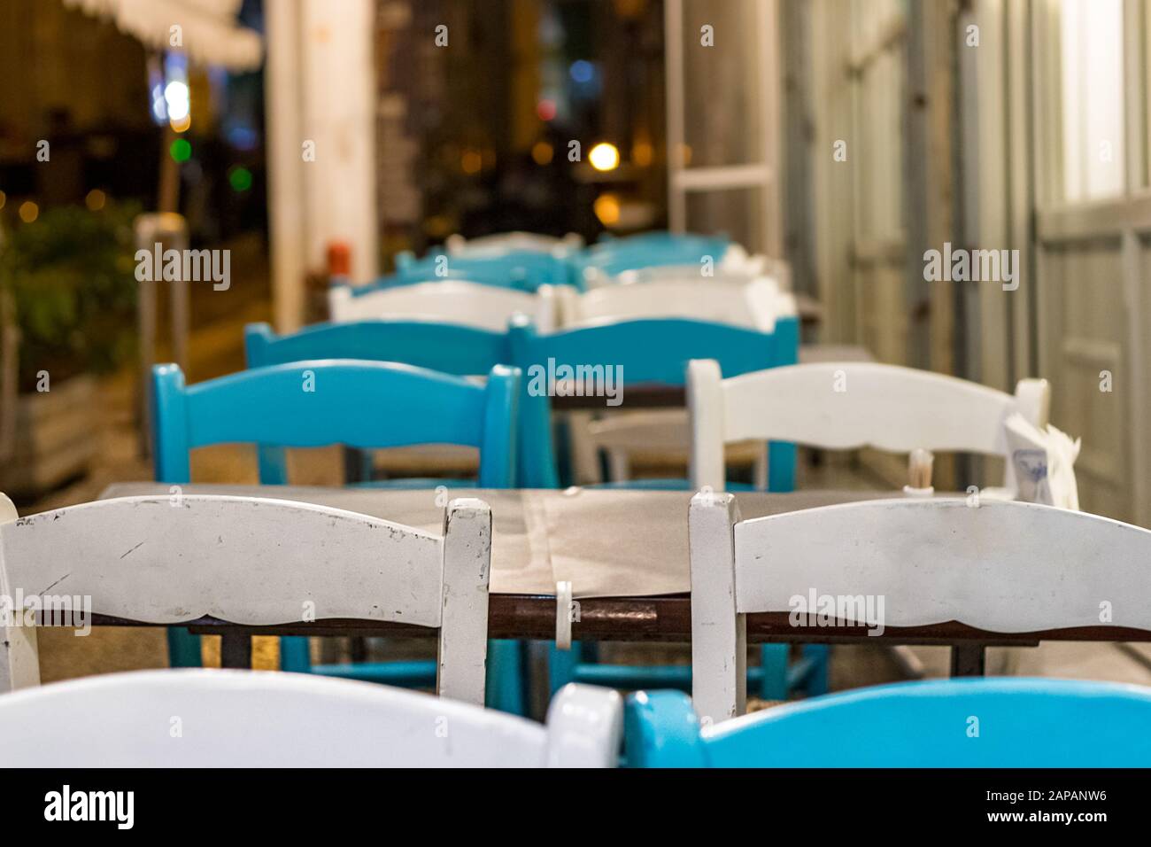 Wooden chairs and table outdoors on the street of a greek taverna Stock Photo