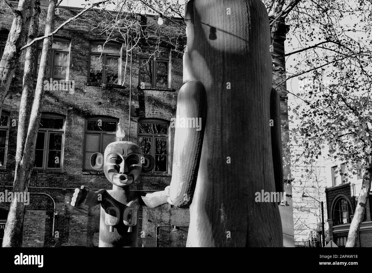 Native American Art in the form of wooden Totem Poles in Pioneer Square, Seattle, Washington State, USA. Shot in black and white. Stock Photo