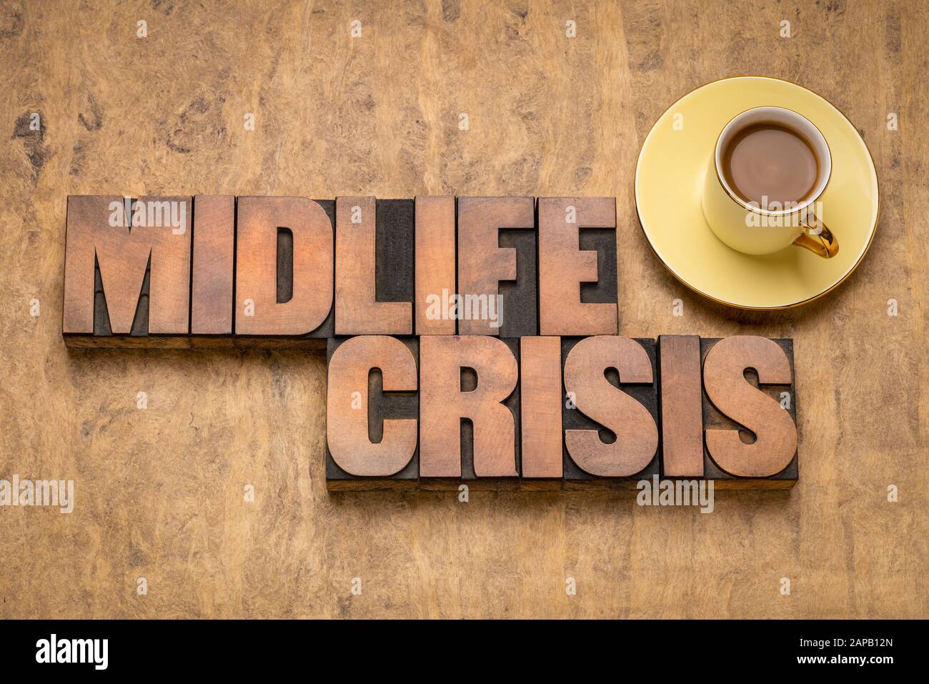 midlife crisis text in vintage letterpress wood type blocks against textured bark paper with a cup of coffee, psychology, identity, self confidence, d Stock Photo