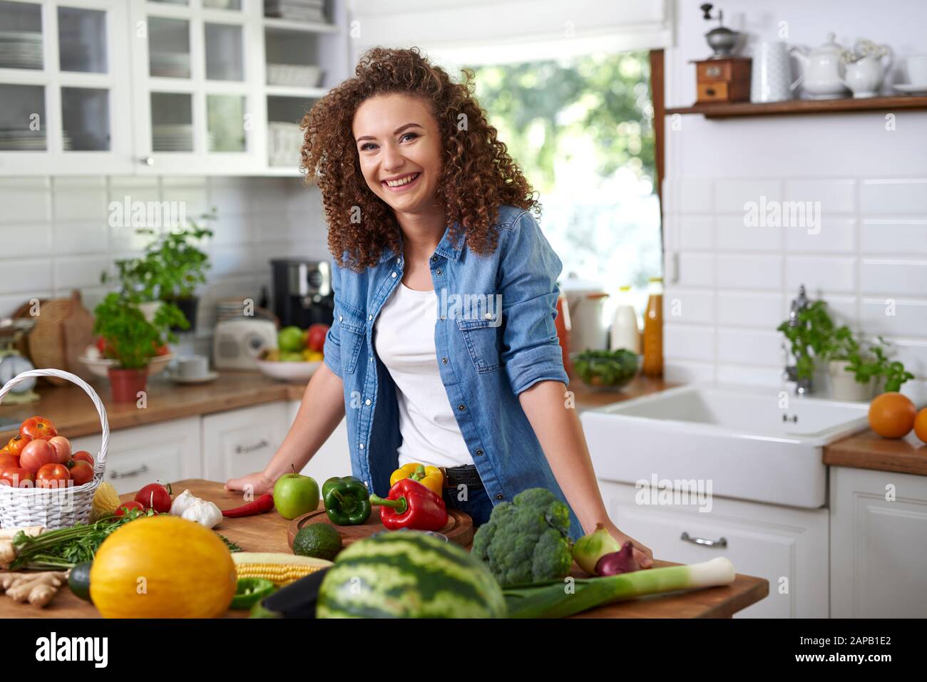 Portrait of smiling young woman in domestic kitchen Stock Photo