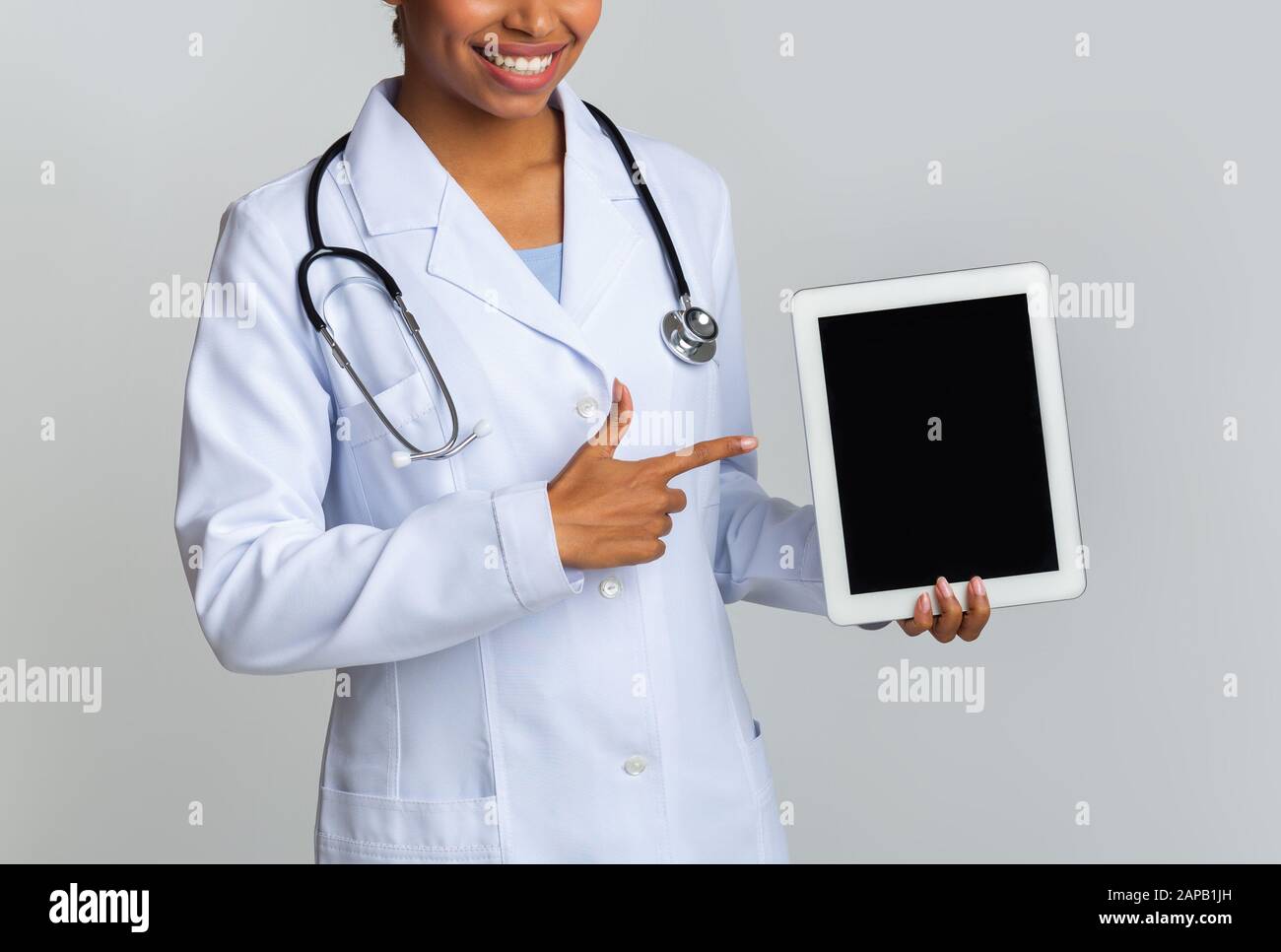 Unrecognizable Black Doctor Pointing At Digital Tablet With Black Screen Stock Photo