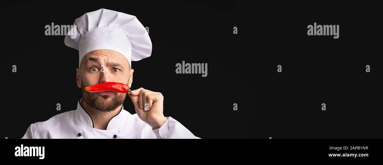 Chef Having Fun Posing With Red Pepper, Black Background, Panorama Stock Photo