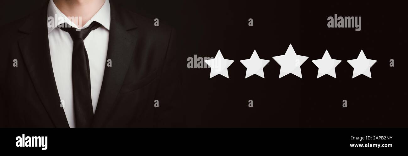 Unrecognizable businessman standing over dark background with five stars icons Stock Photo
