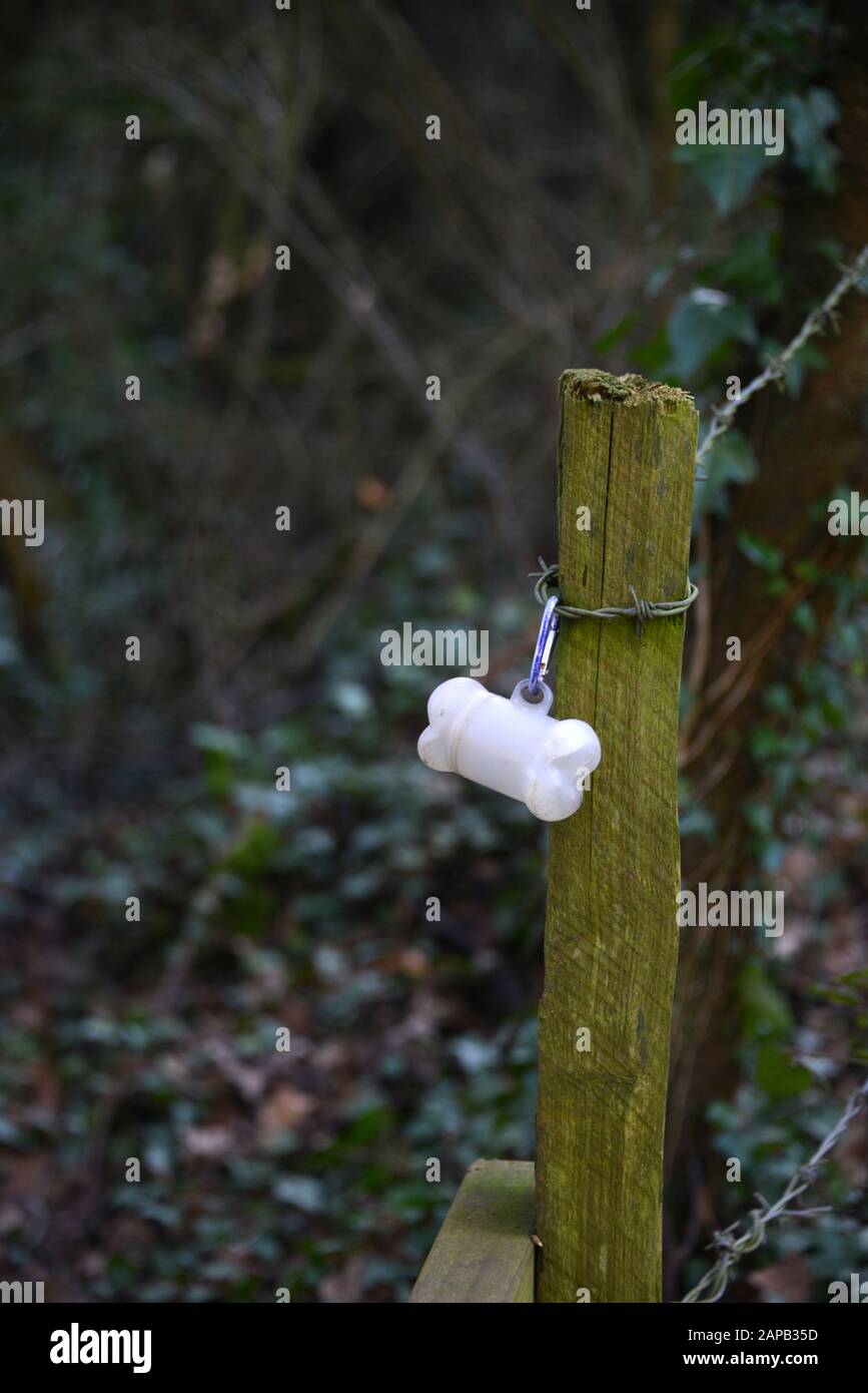 Dog 'poo' bag container on fencepost beside a stile in the north Oxfordshire village of Hook Norton Stock Photo