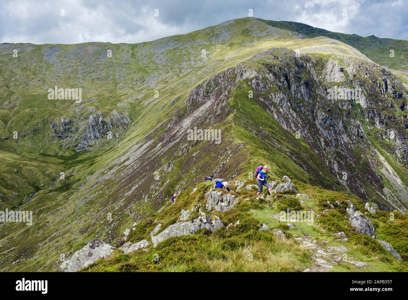 Hikers hiking on path from Carnedd Llewelyn to Pen yr Helgi Du in Carneddau mountains of Snowdonia National Park. Ogwen, North Wales, UK, Britain Stock Photo