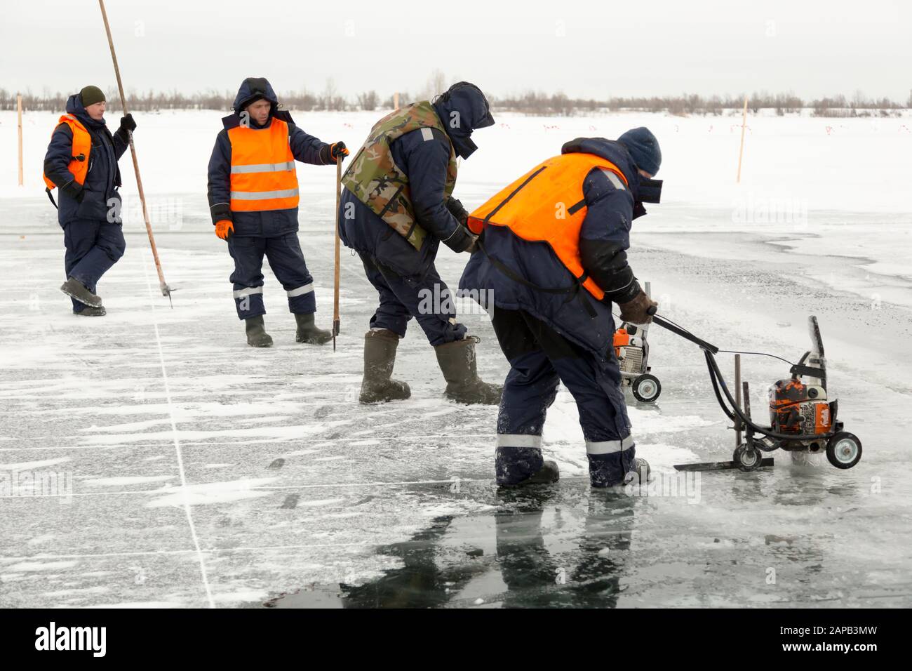 Workers cut ice blocks to the size of ice on a frozen lake Stock Photo