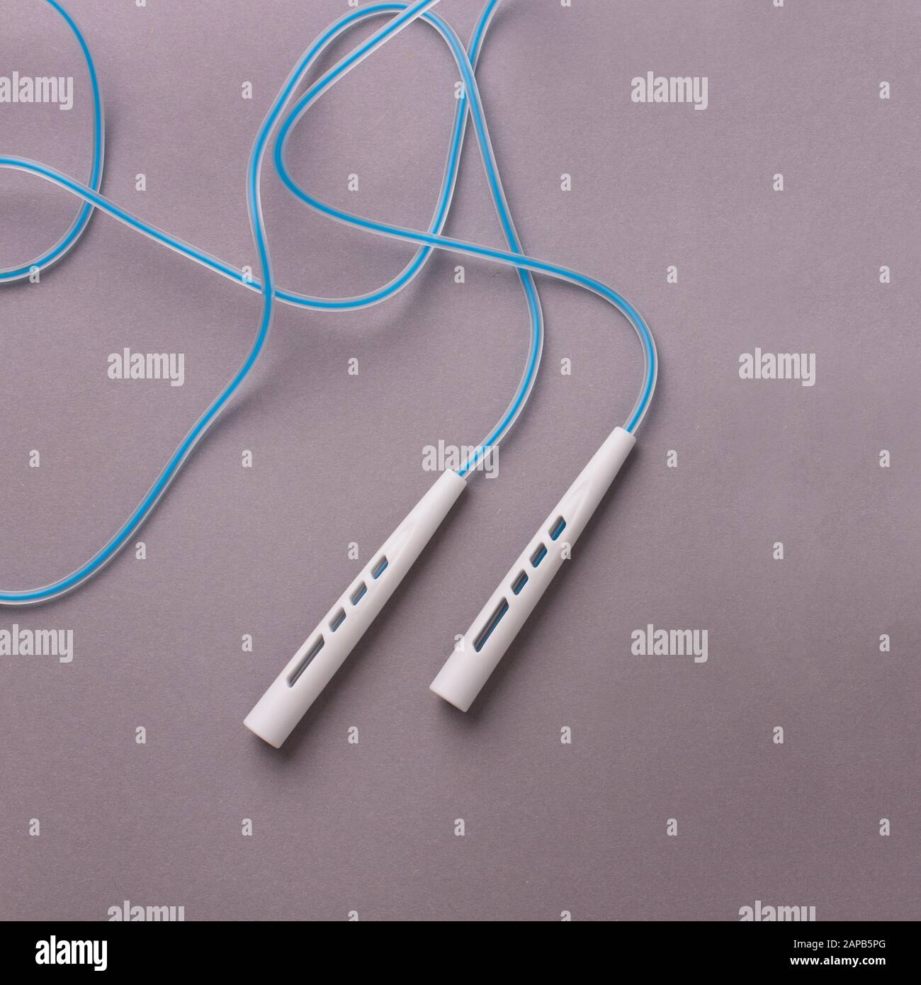 Jumping or skipping rope on gray background Stock Photo