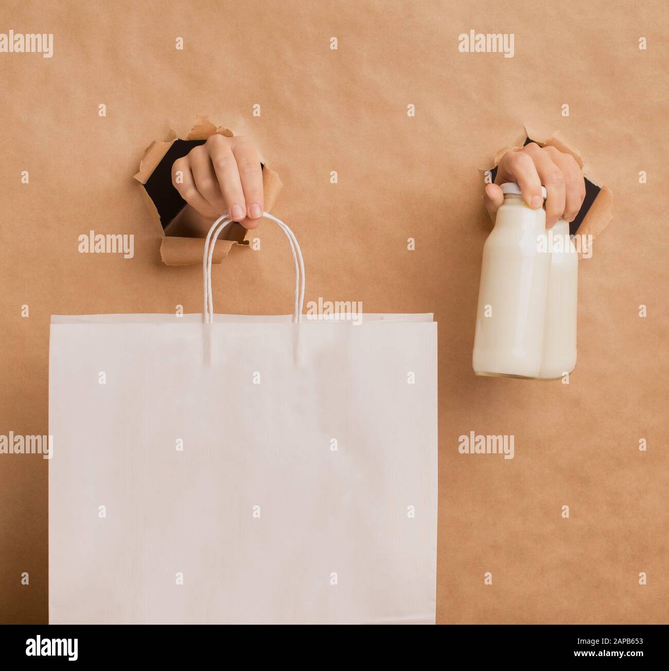 Hands suggesting detox coconut milk and paper bag Stock Photo