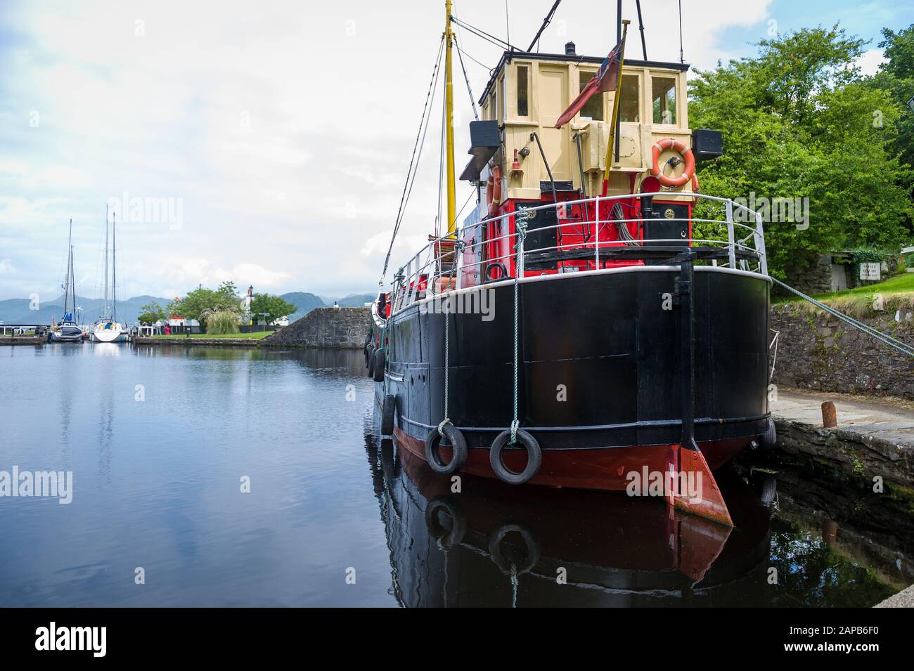Old steel ship with black hull docked at Crinan channel, Scotland Stock Photo